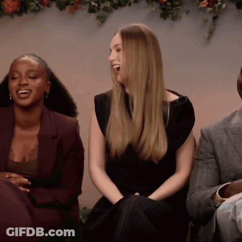 Woman In Black Dress Laughing Beside Man In Suit GIF