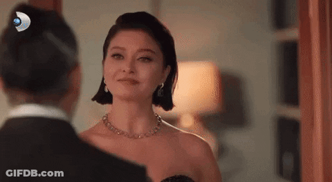 Woman In Black Dress Looking At Man In Tuxedo In Mirror GIF