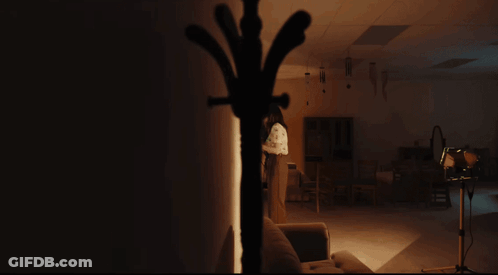 Woman In Black Dress Making Funny Face With Hands Up GIF