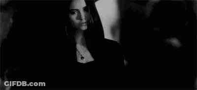 Woman In Black Dress Next To Man In Black And White GIF