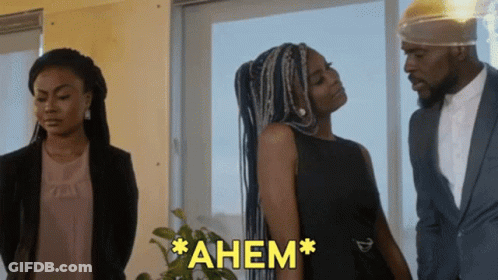 Woman In Black Dress Next To Man In Suit Saying Ahem GIF