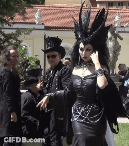 Woman In Black Dress Next To Man In Top Hat GIF