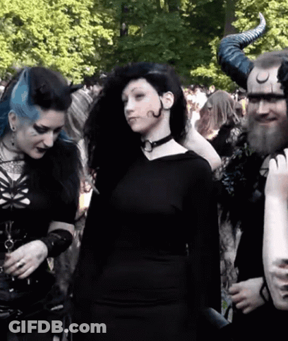Woman In Black Dress Next To Man With Horns GIF