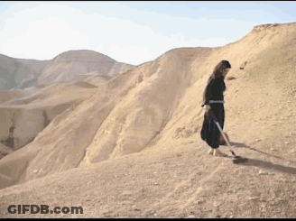 Woman In Black Dress On Desert Hill GIF