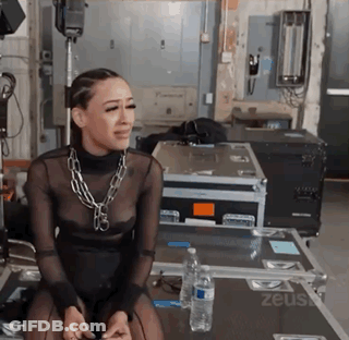 Woman In Black Dress On Table With Zeus Case And Water GIF