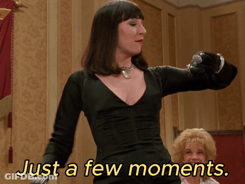Woman In Black Dress Saying Just A Few Moments GIF