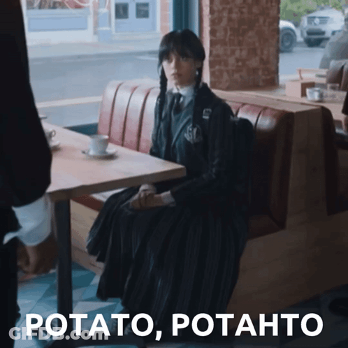 Woman In Black Dress Sitting At Table GIF
