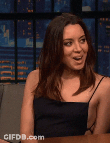 Woman In Black Dress Sitting At Table With Mouth Open GIF