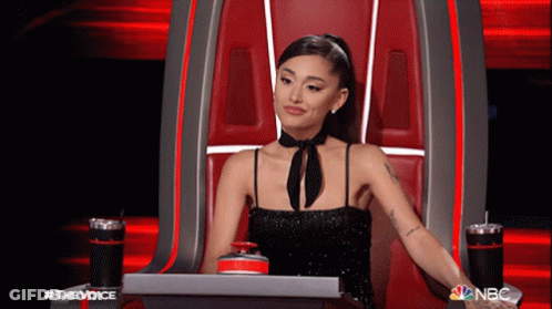 Woman In Black Dress Sitting In Chair With NBC Logo GIF