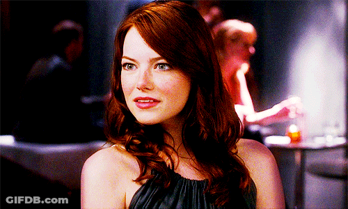 Woman In Black Dress Sitting In Red Chair Mouth Open GIF