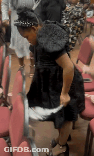 Woman In Black Dress Sitting In Red Chair GIF