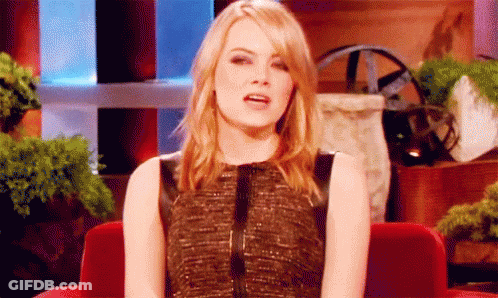 Woman In Black Dress Sitting In Red Chair With Mouth Open GIF