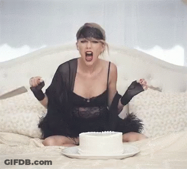 Woman In Black Dress Sitting On Bed With Cake GIF