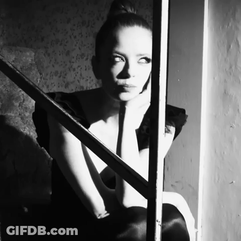 Woman In Black Dress Sitting On Stairs GIF