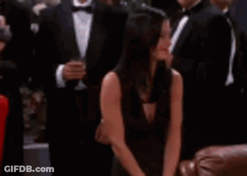 Woman In Black Dress Sitting With Man In Tuxedo GIF