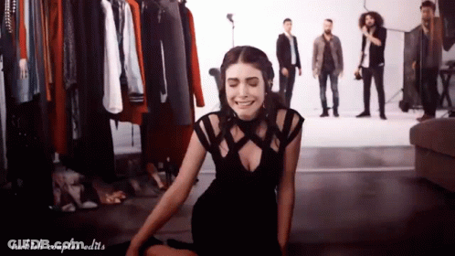 Woman In Black Dress Sitting With Men Standing GIF