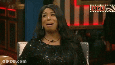 Woman In Black Dress Sitting With Mouth Open And Live Sign GIF