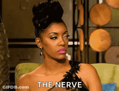 Woman In Black Dress Sitting With Nerve On Face GIF