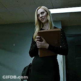 Woman In Black Dress Smiling Holding Folder GIF