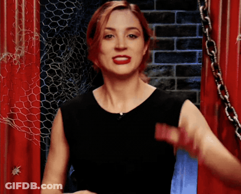 Woman In Black Dress Standing Before Red Door GIF