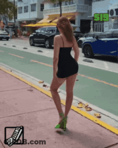 Woman In Black Dress Standing By S19 Sign GIF