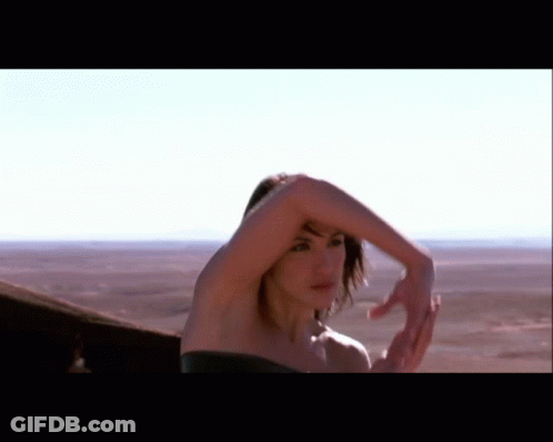 Woman In Black Dress Standing In Desert GIF