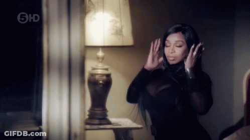 Woman In Black Dress Standing In Front Of Lamp GIF
