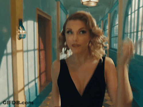Woman In Black Dress Standing In Hallway GIF