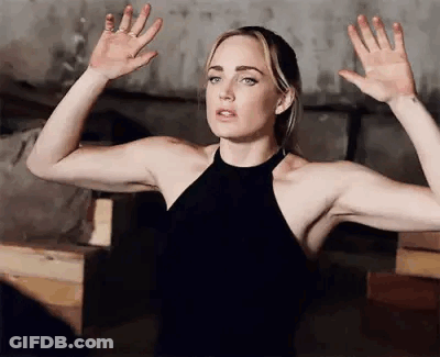 Woman In Black Dress Standing With Hands Up GIF