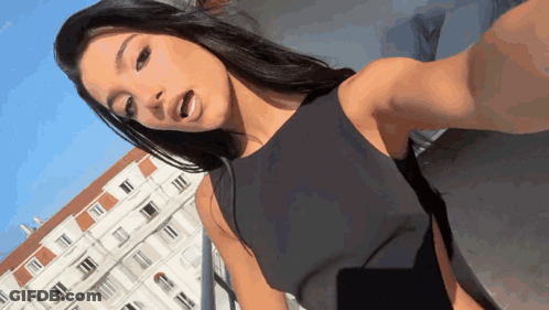 Woman In Black Dress Taking Selfie GIF