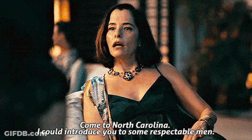 Woman In Black Dress Talking To Man In Dark Room GIF