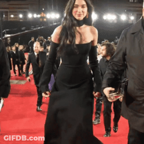 Woman In Black Dress Walking On Red Carpet GIF