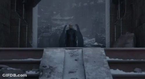 Woman In Black Dress With Man Behind At Castle GIF