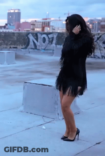Woman In Black Fringed Dress In Front Of No1 Graffiti Wall GIF