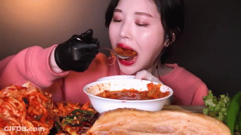 Woman In Black Gloves Eating Bowl Of Food GIF