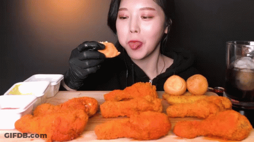 Woman In Black Gloves Eating Fried Chicken With Tongue Out GIF