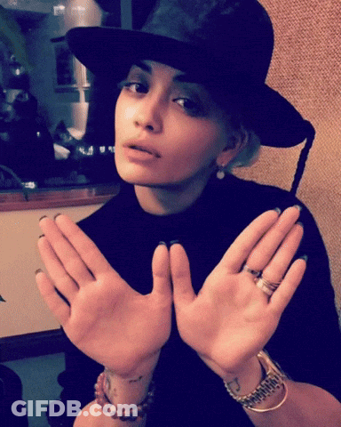 Woman In Black Hat And Bracelets Holding Hands Up GIF