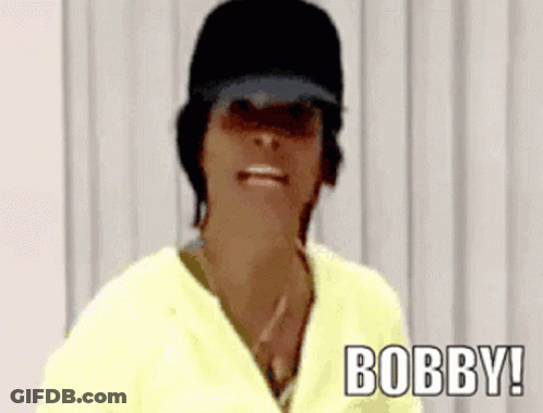 Woman In Black Hat And Yellow Shirt Saying Bobby GIF