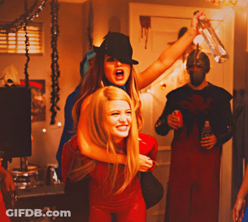 Woman In Black Hat Carrying Woman In Red Outfit GIF