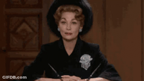 Woman In Black Hat Sitting At Table GIF