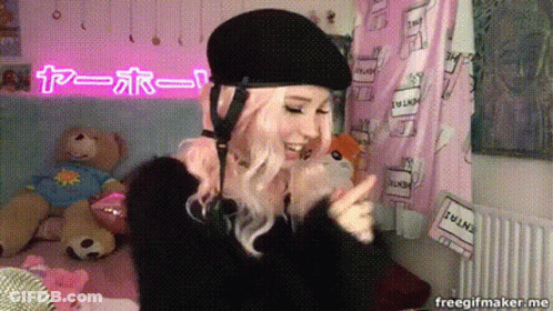 Woman In Black Helmet In Front Of Pink I Love You Sign GIF