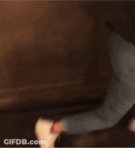 Woman In Black Jacket And Blue Jeans Walking Down Dark Hallway GIF