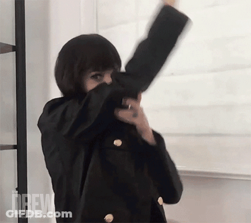 Woman In Black Jacket Dancing In Front Of Drew Board GIF