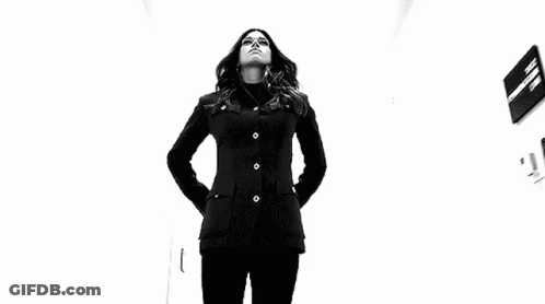 Woman In Black Jacket Holding Two Sticks GIF