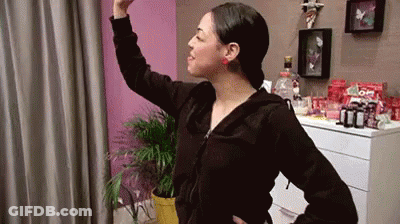 Woman In Black Jacket In Front Of Pink Wall GIF