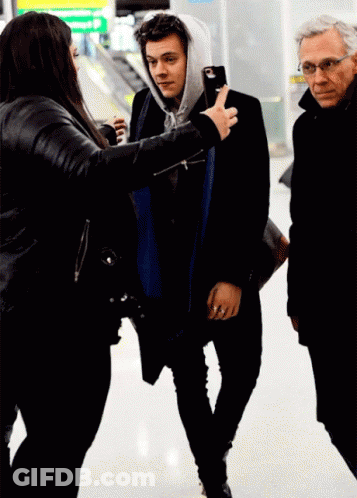Woman In Black Jacket Photographing Man In Hoodie GIF