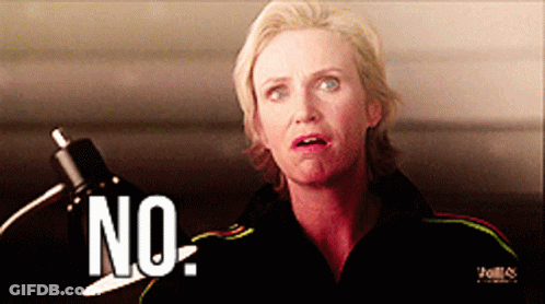 Woman In Black Jacket Saying No In Front Of Lamp GIF
