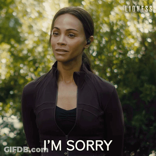 Woman In Black Jacket Says I'm Sorry In Front Of Trees GIF