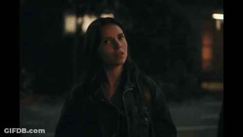 Woman In Black Jacket Standing In Darkness GIF