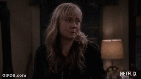 Woman In Black Jacket Standing In Front Of Lamp And Netflix Logo GIF